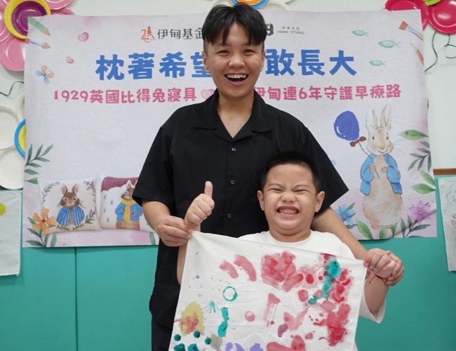 慢飞天使元元自信展示枕头彩绘成果。