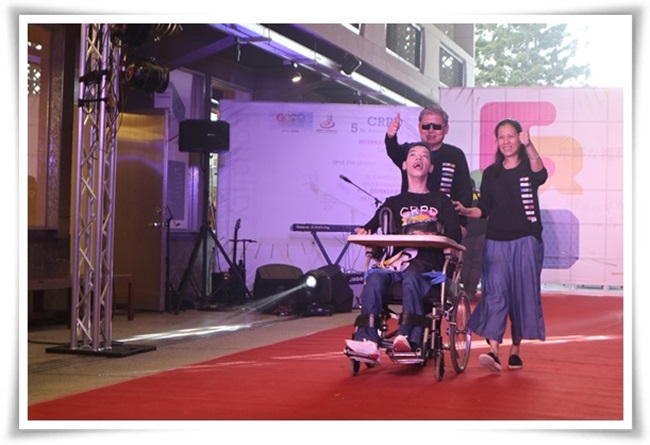 伊甸董事长成亮与卫福部署长简慧娟携手身障艺术家哲毅一同站上舞台，展示NODD共同合作的创作潮服
