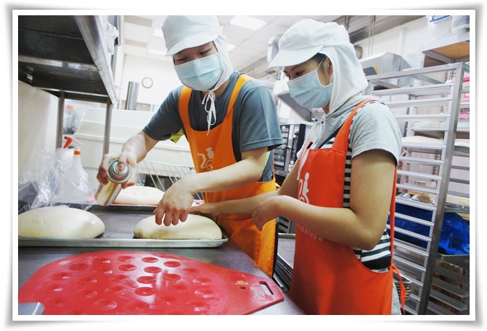 喜爱烘焙的庇护员工小婕(右)，认真学习烘焙技巧，期许未来能成为烘焙师傅。
