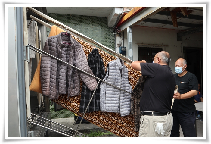 伊甸干燥消毒车操作人员将阿公的衣服与寝具上架，进行除溼、消毒与烘干等清洁工作。