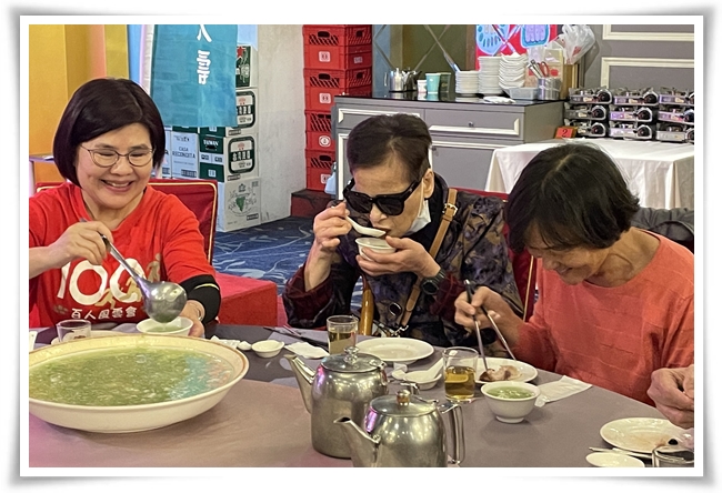 台湾人寿高三通讯处企业志工坐在旁为视障朋友舀汤