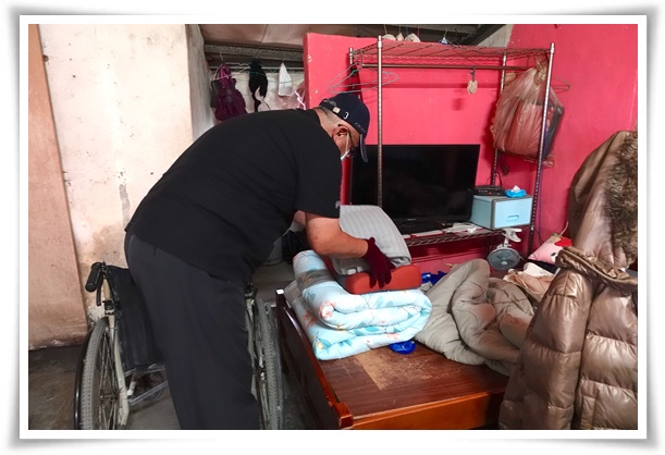 伊甸干燥消毒车操作人员协助将完成消毒的寝具，依序折好进行收纳。