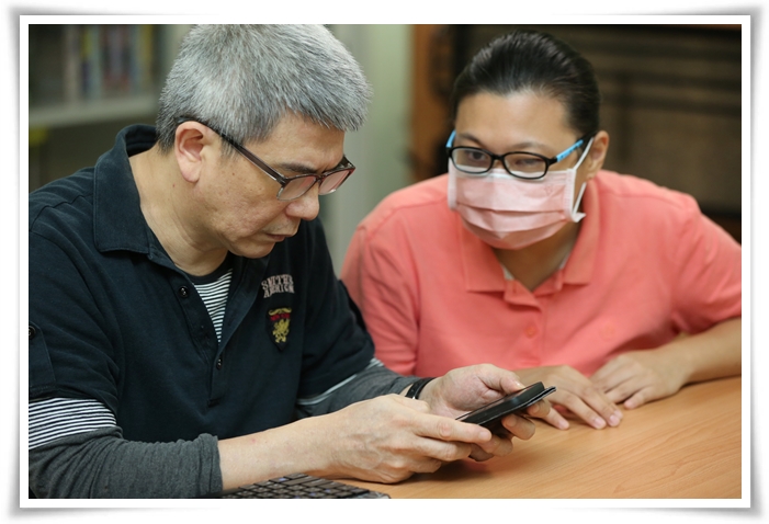 视障生活重建手机课程老师孙念慈(右)细心的提醒视障者亭瑜(左)，在操作手机时的小细节