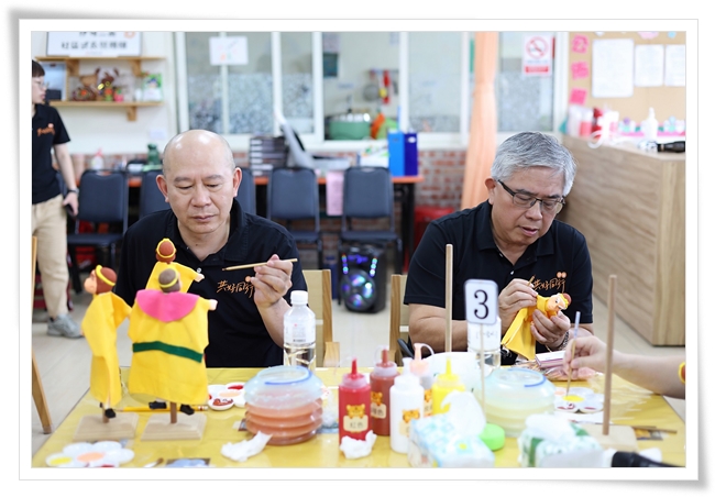 伊甸董事长陈宇昭（右）、副执行长林文宾一起彩绘戏偶，与大家同乐