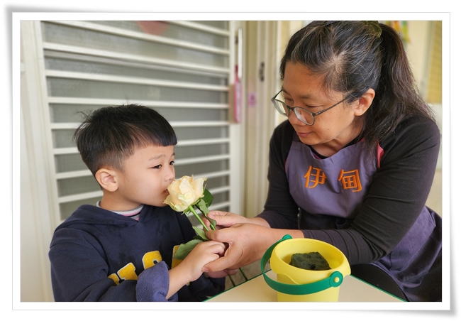 老师引导幼童感受玫瑰香气