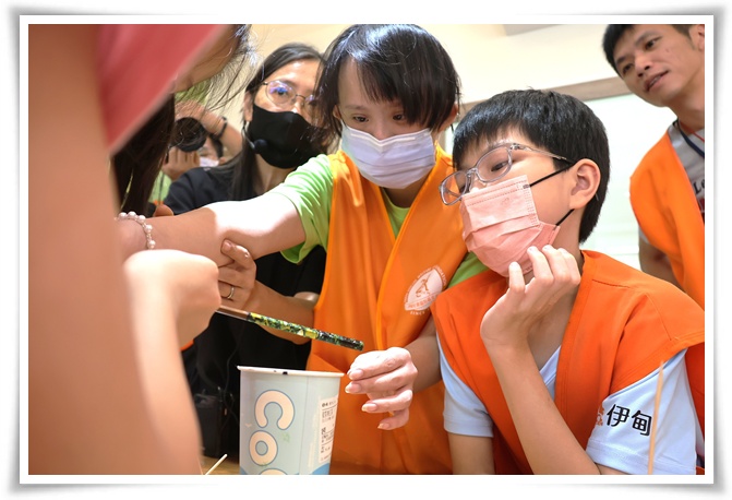 伊甸彭福小作所的小靜展現手作能力，認真帶領小小志工體驗漆筷創作的樂趣。