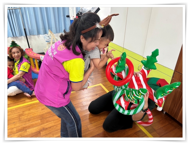 企業志工協助幼童，丟圈圈到聖誕樹上
