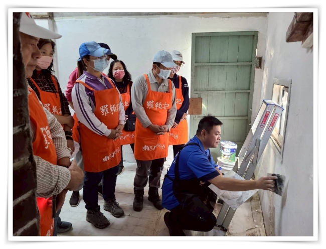 伊甸羅賴把講師教導志工如何粉刷牆壁