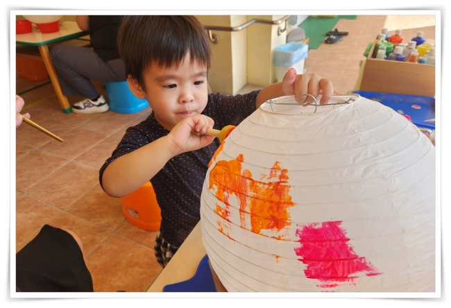 小安使用顏料在燈籠面上色