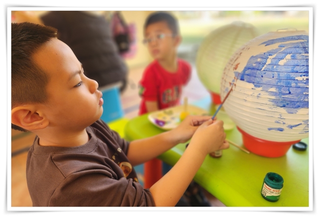 幼童使用顏料在燈籠面上色